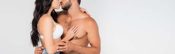 raccolto panoramico di donna sexy toccare e baciare uomo senza camicia isolato su grigio - Foto, immagini