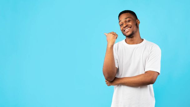 Black Guy Pointing Thumb Aside At Blank Space, Blue Background - Photo, Image