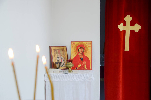 Kerzen vor Ikonen in der orthodoxen Kirche. Brennende Wachskerzen, Kreuz und Ikonen im Kloster - Foto, Bild