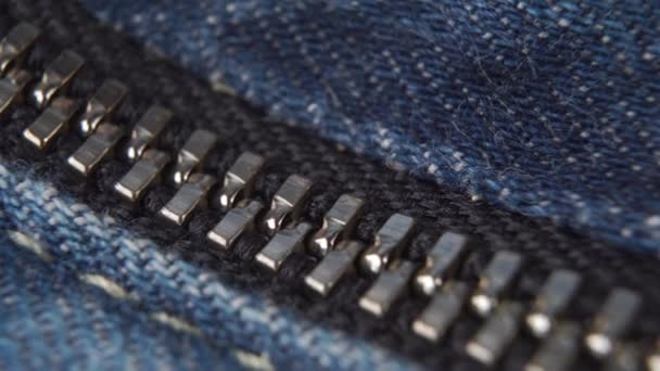 Zavřený kovový zip džín zblízka. Modrá džínová látka. Makro snímek - Záběry, video