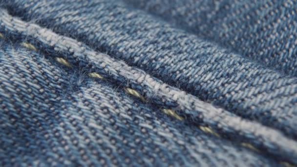 Cucite jeans blu con fili arancioni. macro dolly shot - Filmati, video