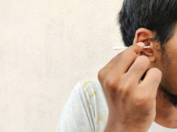 Jižní indián čištění uší s bavlněným pupenem, Izolované na bílém pozadí - Fotografie, Obrázek