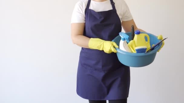 Donna delle pulizie con guanti porta diversi prodotti per la pulizia. Concetto di pulizia e disinfezione. - Filmati, video