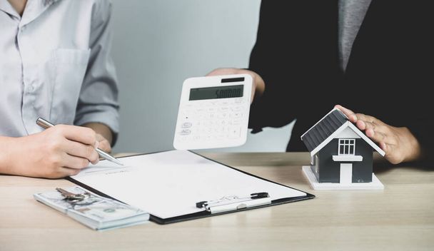 L'agent immobilier explique le contrat d'affaires, le loyer, l'achat, l'hypothèque, le prêt ou l'assurance habitation à l'acheteuse.. - Photo, image