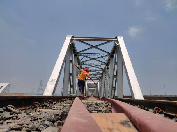 man at railway tracks iron bridge unique angle shot - Photo, Image