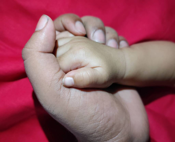 il padre che tiene il palmo di bambino in mano che mostra l'amore - Foto, immagini
