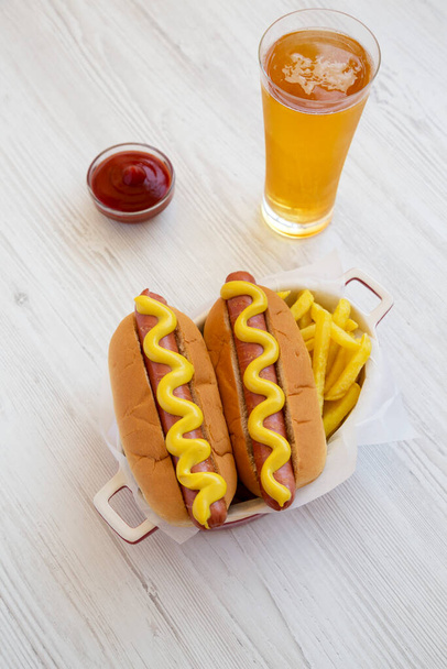 Domowa musztarda Hot Dog z frytkami na białym drewnianym tle, wysoki kąt widzenia.  - Zdjęcie, obraz
