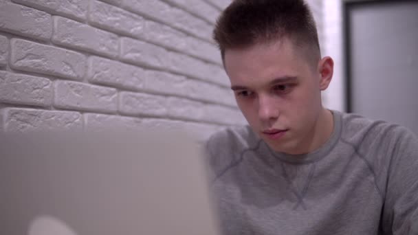 Jeune homme choqué utilisant un ordinateur portable, homme triste lire de mauvaises nouvelles, étudiant ou pigiste homme - Séquence, vidéo