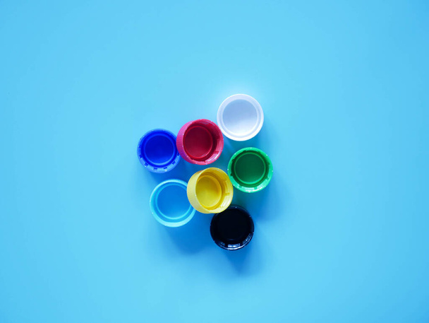 műanyag palack kupakok elszigetelt kék háttér - Fotó, kép