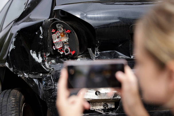 Femme conducteur prenant des photos de voiture endommagée après un accident pour réclamation d'assurance sur téléphone portable - Photo, image