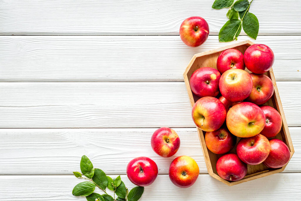 Group of red apples in wooden tray with leaves. Autumn harvest - Fotoğraf, Görsel
