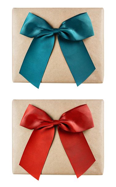 Boîtes cadeaux de vacances enveloppées dans du papier brun avec des arcs verts et rouges isolés sur fond blanc. Pose plate. - Photo, image