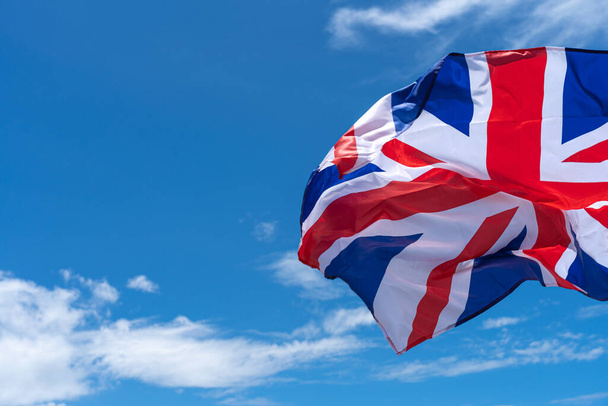 Sventolando bandiera del Regno Unito sotto sfondo cielo blu. - Foto, immagini