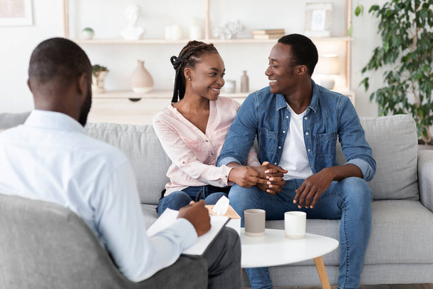 Terapia di coppia di successo. coniugi neri riconciliati abbracciando in ufficio terapeuta - Foto, immagini