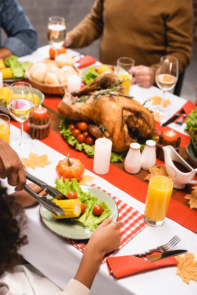 cropped view of multiethnic family having festive dinner on thanksgiving day - 写真・画像