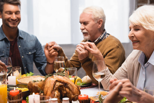 foyer sélectif de la famille avec les yeux fermés tenant la main sur thanksgiving  - Photo, image
