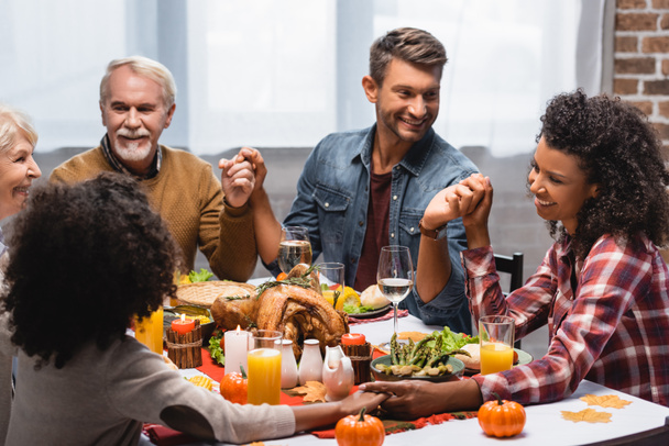 joyful and multiethnic family celebrating thanksgiving at home - 写真・画像