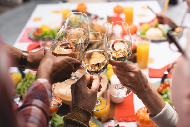 partial view of multiethnic relatives clinking wine glasses while celebrating thanksgiving day - Photo, Image