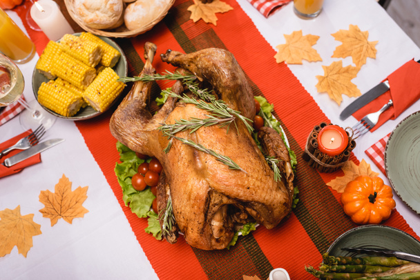 Top view of tasty turkey near thanksgiving dinner and decorations on table  - Fotó, kép