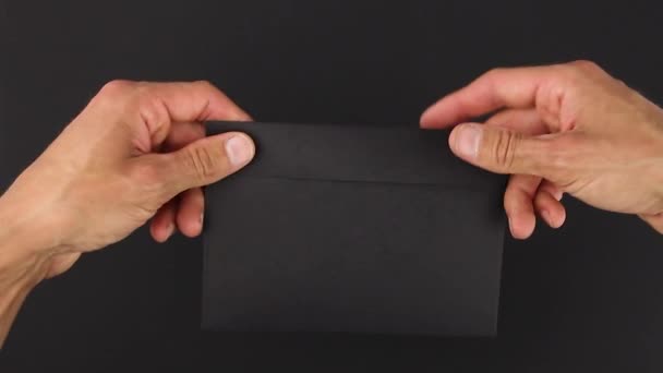 fekete boríték kézről kézre történő átadása fekete háttérrel, egyik kezes átadás, másik átvétel levél, gyanús levelezés titkos átadása, nyomozati bizonyítékcsomag - Felvétel, videó