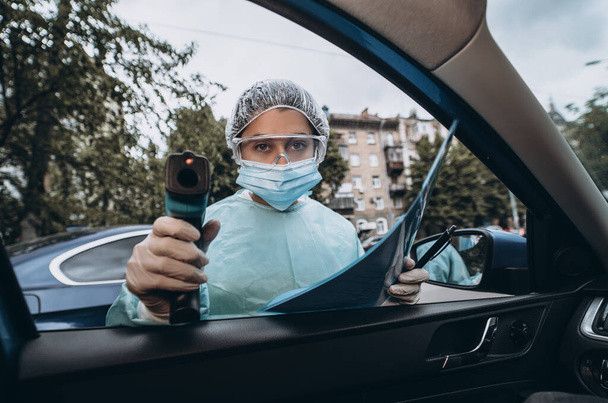 Lékařka použít infračervený teploměr pistole pro kontrolu tělesné teploty - Fotografie, Obrázek