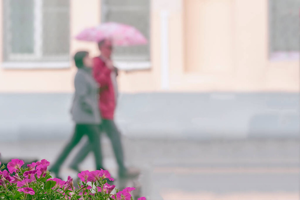 Walking happy couple together, city street in rainy day. Concept of modern city, love, lifestyle. Abstract blurred background - Photo, Image