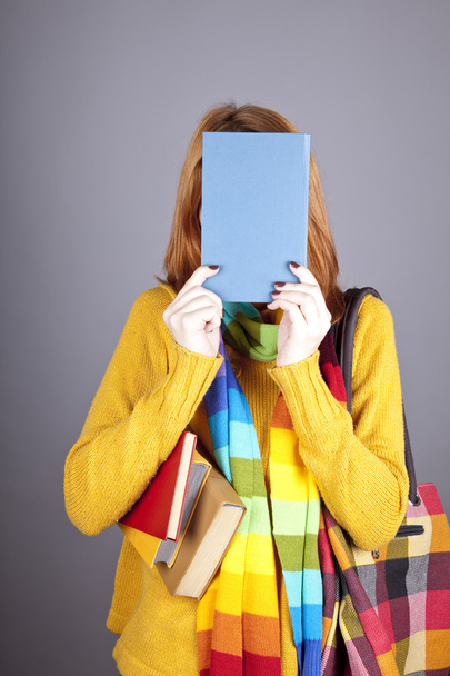 Student girl with blue book near head. - Φωτογραφία, εικόνα