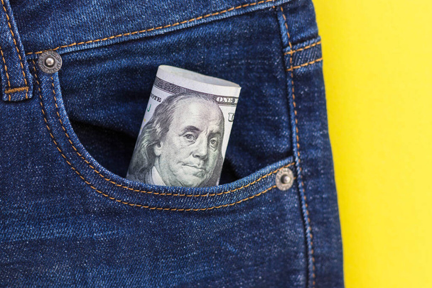 Closeup of 100 dollar bill sticking out from jeans pocket. American banknote. Flat lay, copy space. - Foto, imagen