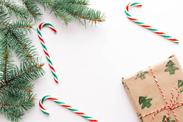 Різдвяна композиція. Подарунки, ялинові гілки, червоні та зелені різдвяні цукерки, прикраси на білому тлі. Концепція Різдва, зими, Нового року. Плоске компонування, вид зверху, простір для копіювання
 - Фото, зображення