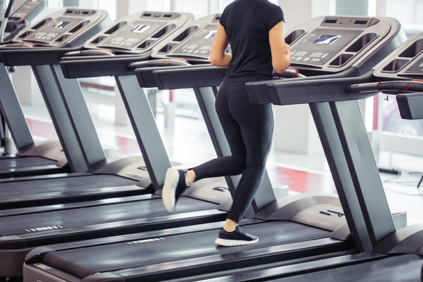 Young fit woman running on treadmill - Foto, Bild