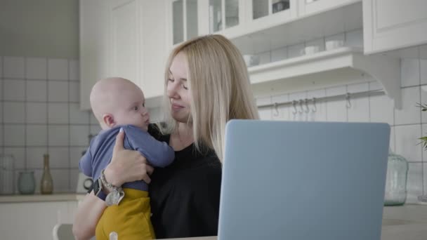 Moeder het verzorgen van haar baby tijdens het werken thuis - Video