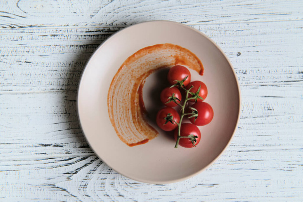Verse cherry tomaten saus op witte tafel achtergrond, bovenaanzicht. Rijpe groenten - Foto, afbeelding