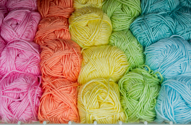 Close-up van strengen van draad in turkoois, blauw, geel, oranje en groen pastel kleuren. Achtergrond van de draad. - Foto, afbeelding