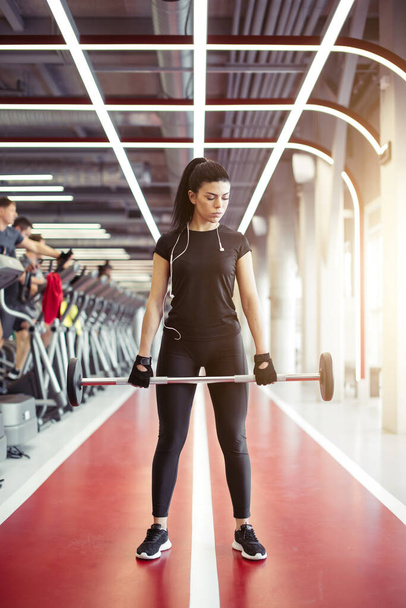 woman preparing to practice deadlift with weights in gym - Fotó, kép
