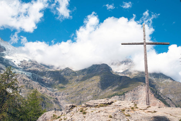 Альпийский крест. Альпийский пейзаж, содержащий большой деревянный крест. Горный ландшафт Австрии с голубым небом летом - Фото, изображение