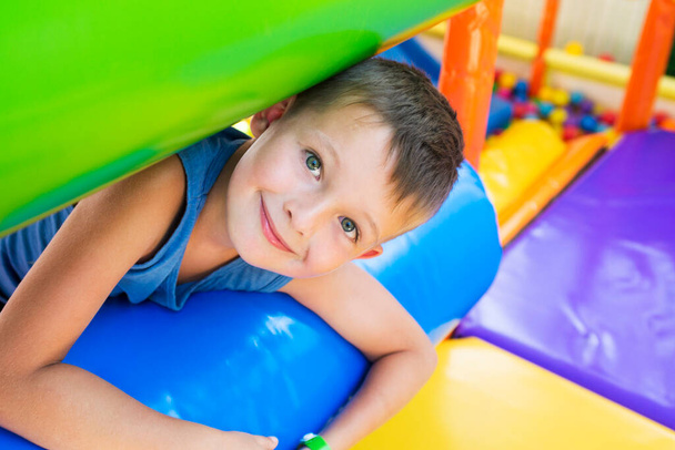 Boy playing on the playground, in the children's maze. Child playing on a color playground. - Foto, Imagen