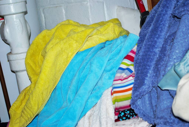 Stapel vuile handdoeken die gewassen moeten worden in een wasruimte in de kelder - Foto, afbeelding