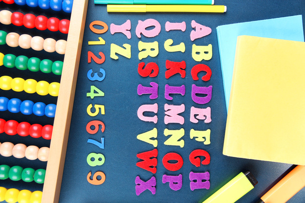 Colorful numbers, abacus, books and markers on school desk background - Zdjęcie, obraz