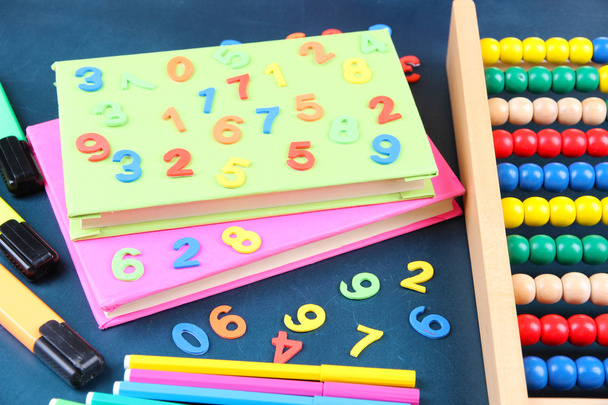 Colorful numbers, abacus, books and markers on school desk background - Foto, afbeelding