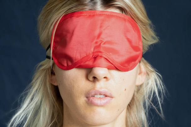 portrait of a girl with a red blindfold on an isolated background close up - Photo, Image