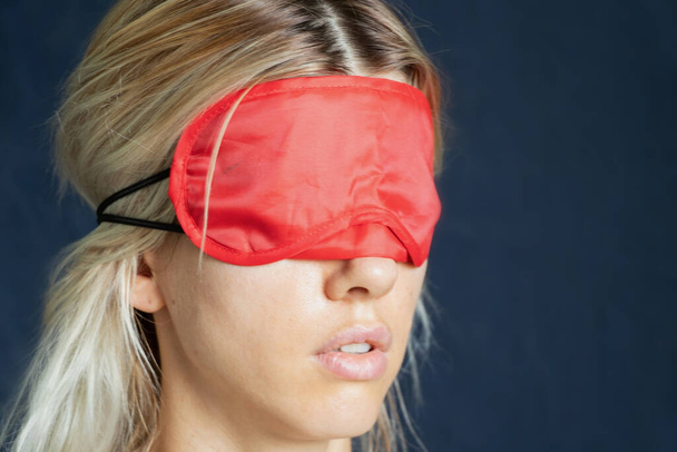portrait of a girl with a red blindfold on an isolated background close up - Fotó, kép