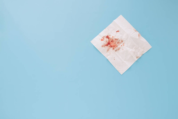 Krew na papierowej serwetce wyizolowana na niebieskim tle. Wysokiej jakości zdjęcie - Zdjęcie, obraz