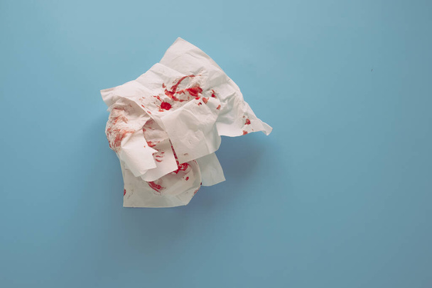 close up of blood on paper napkins on blue background . High quality photo - Foto, afbeelding