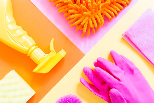 Colorful cleaning set of tools on the bright background. Yellow spray, pink gloves, orange rag. Housekeeping and cleaning the house concept - Foto, Imagem