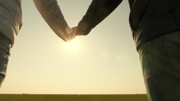 Hands of man and woman at sunset. sunny glare through palms. loving couple holding hands at sunset. Extend your hand to a friend. suns rays shine through your fingers. Love, Happiness and Friendship. - Footage, Video