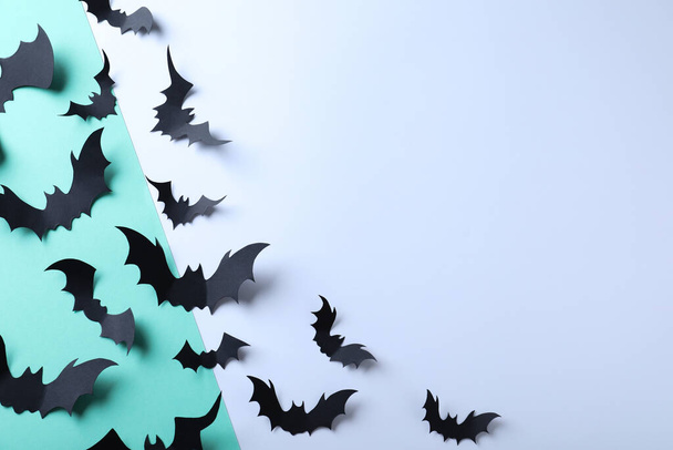 Many black paper bats on color background, flat lay with space for text. Halloween decor - Foto, Imagem