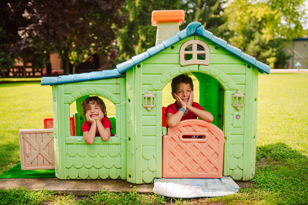 Beaux garçons caucasiens jouent dans une maison colorée dans le parc. Une journée dans la nature - Photo, image