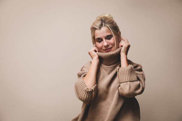 Happy woman in stylish sweater on beige background. Space for text - Фото, изображение