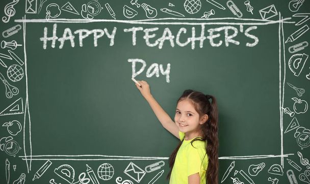 Cute little girl writing phrase Happy Teacher's Day on chalkboard - Fotografie, Obrázek