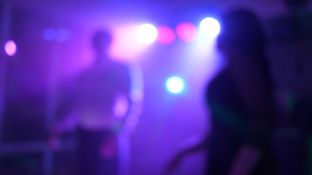 Vacaciones divertidas en el club, siluetas de la gente, baile, música, espectáculo de luz. Un grupo de jóvenes y elegantes personas multiétnicas se divierten y bailan durante una colorida fiesta. - Foto, imagen